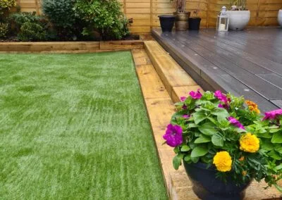 Fresh lawn edged by timber and flower planting